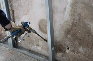 Man spraying insulation into walls